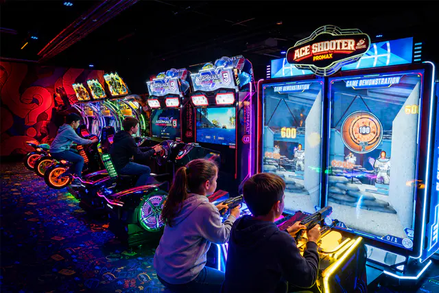 Des enfants jouent ensemble aux bornes d’arcade chez Smile World