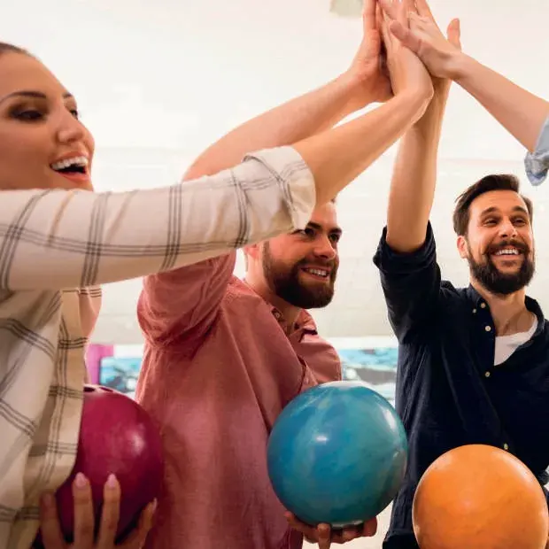 Équipe réunie autour de boules de bowling